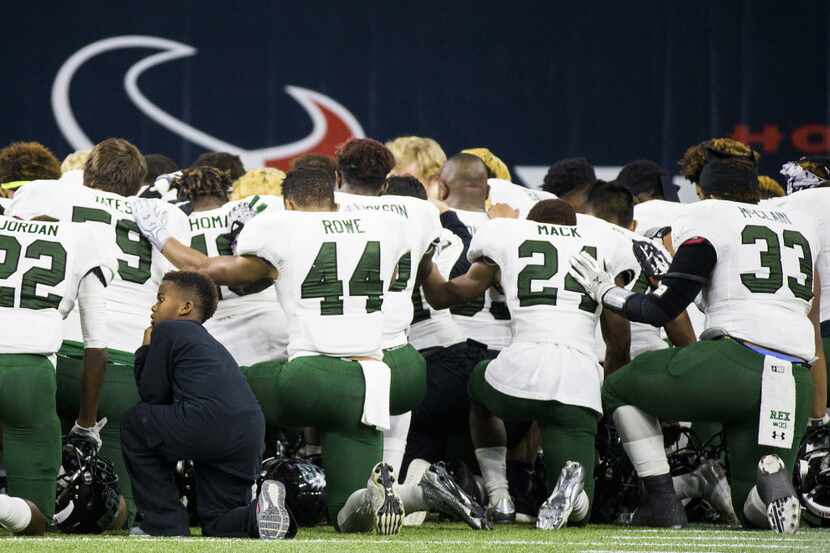 Mansfield Lake Ridge player kneel in prayer before the Class 5A Division I state...