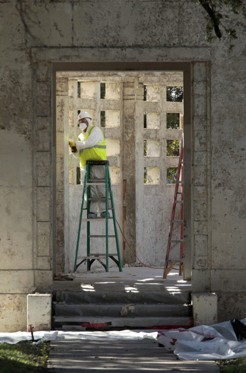 A worker removes paint as Phase II of renovations of Dealey Plaza continue on the pergola on...