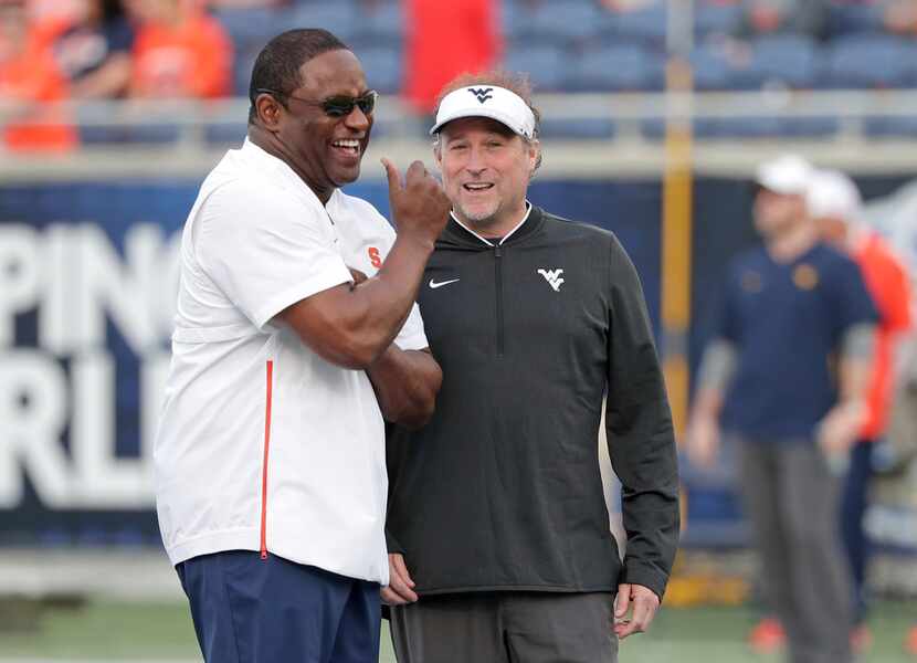 Syracuse head coach Dino Babers, left, and West Virginia head coach Dana Holgorsen greet...