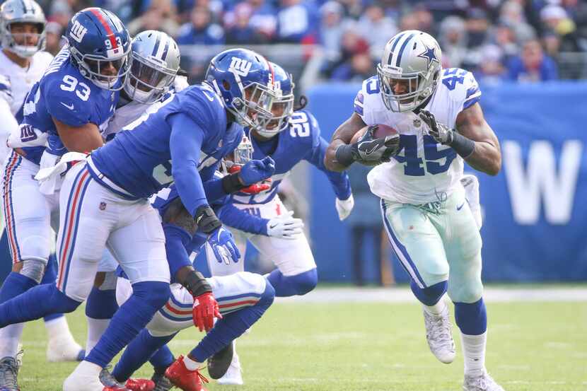 Dallas Cowboys running back Rod Smith (45) carries the ball as a herd of New York Giants...