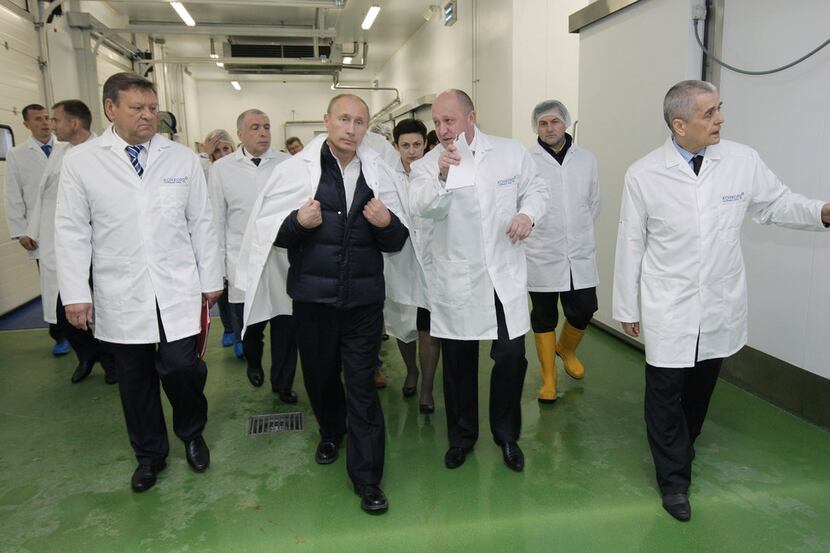 Yevgeny Prigozhin (center right) with President Vladimir Putin at his school lunches factory...