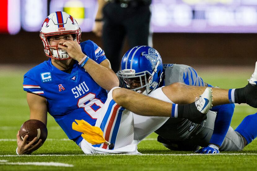 A penalty flag flies after SMU quarterback Ben Hicks (8) was pulled down by his face mask by...