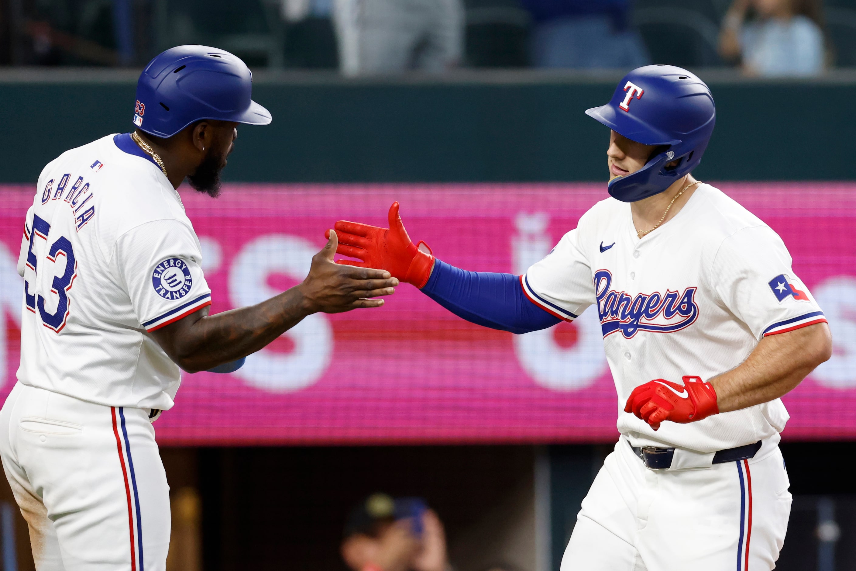 Texas Rangers left fielder Wyatt Langford (36) high-fives right fielder Adolis Garcia (53)...