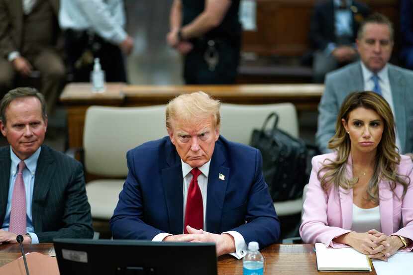 Former President Donald Trump sits at the defense table with his attorney's Christopher...