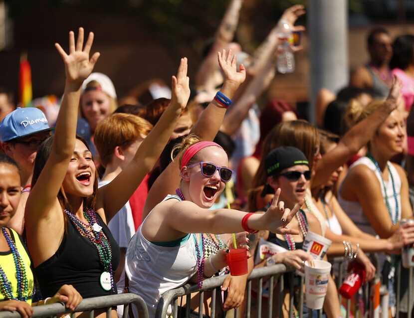 Thousands of people lining Cedar Springs Rd. plead for beads from passing floats in the Alan...