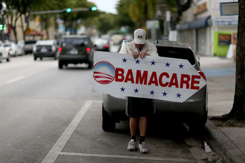 Una persona promociona registros para el seguro médico conocido como "Obamacare" en Miami,...