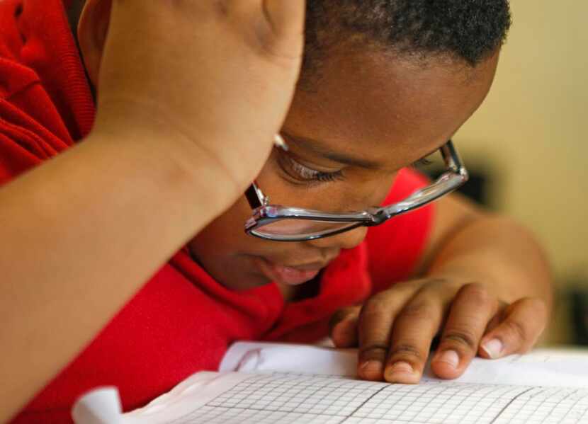
Cameron Dillard, 9, work on his math homework during study time at Voice of Hope Ministries...