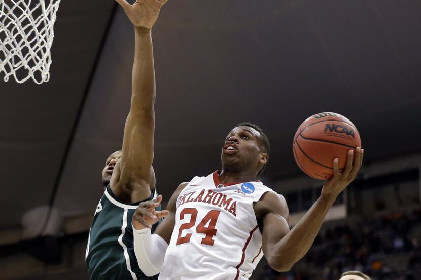 FILE - Oklahoma's Buddy Hield (24) drives past Michigan State's Marvin Clark Jr., left, and...