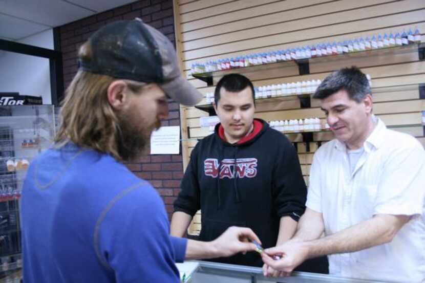 Frank Malara (right), owner of The Vapor Zone, helps Lewisville resident Max Gaebler select...