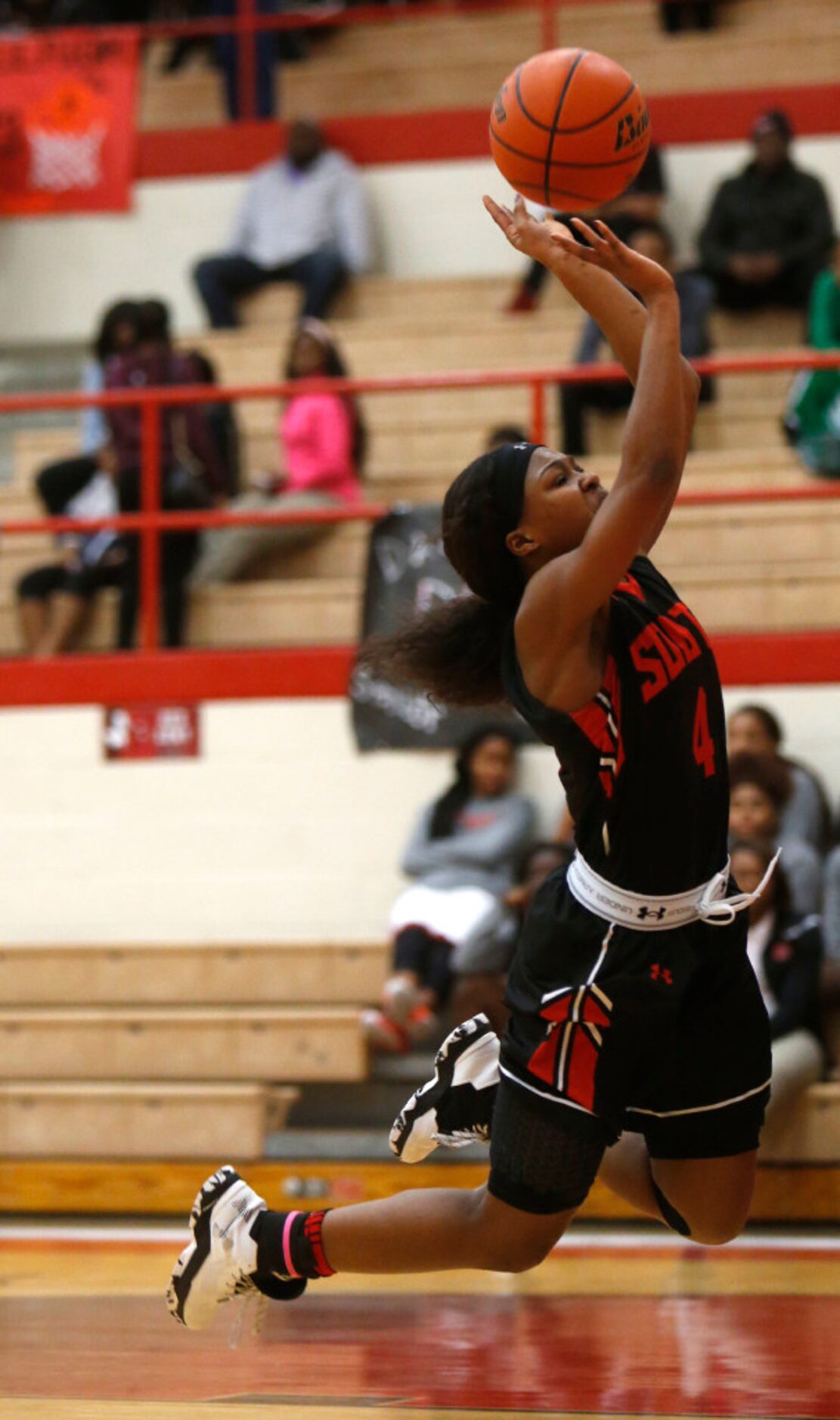 South Grand Prairie player Amber Bacon (4) trips on a lay up against Cedar Hill during the...