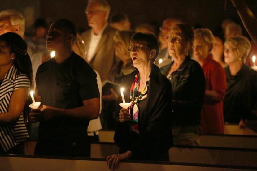 
People hold candles during a a prayer vigil and memorial at Wilshire Baptist Church for...