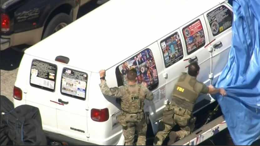 This frame grab from video provided by WPLG-TV shows FBI agents covering a van after the...