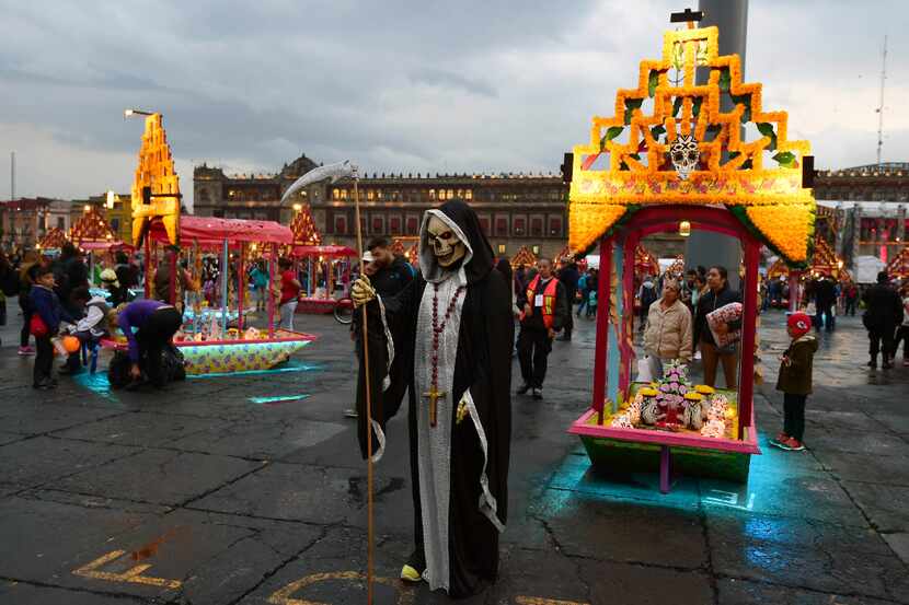 A person dressed as Death stood in front of an altar decorating Mexico City's Zocalo square...