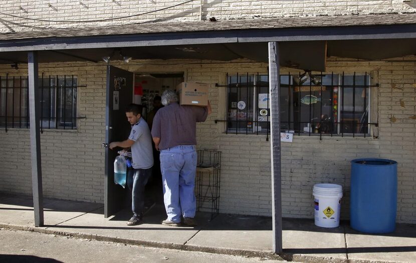 
Terry Mullins brings in a box of worms as a customer exits with a bag of minnows at Clark’s...