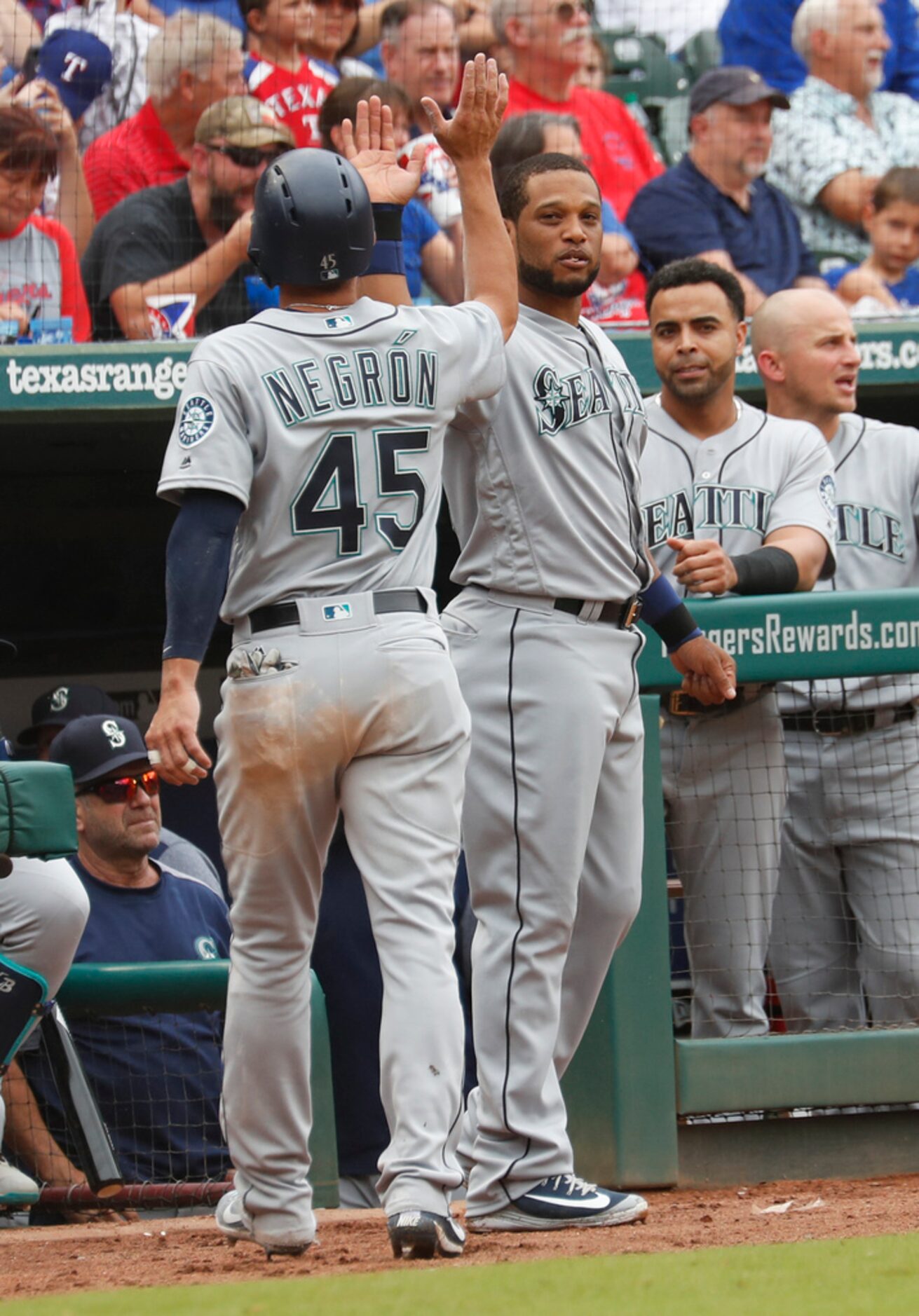 Seattle Mariners' Kristopher Negron (45) is congratulated by Robinson Cano, right, after...