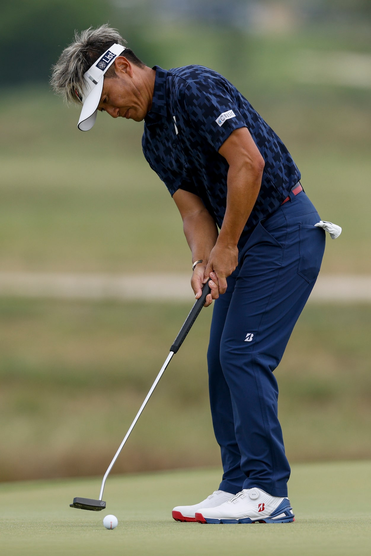 Katsumasa Miyamoto of Japan putts for birdie on the seventh hole during the first round of...