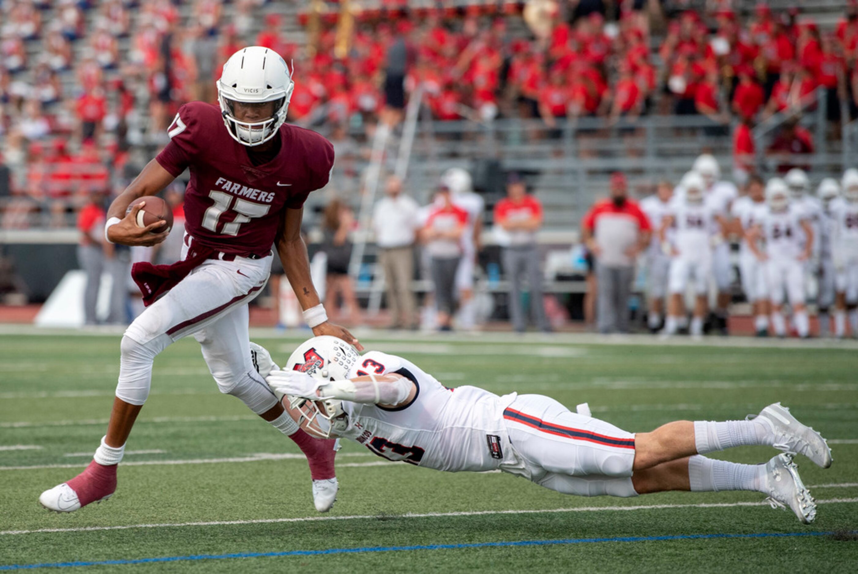 Lewisville junior quarterback Taylen Green (17) gets past diving McKinney Boyd senior...