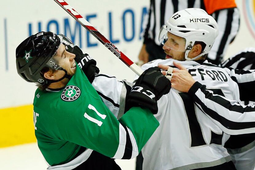 The Los Angeles Kings' Kyle Clifford (13) grabs the Dallas Stars' Curtis McKenzie (11) by...
