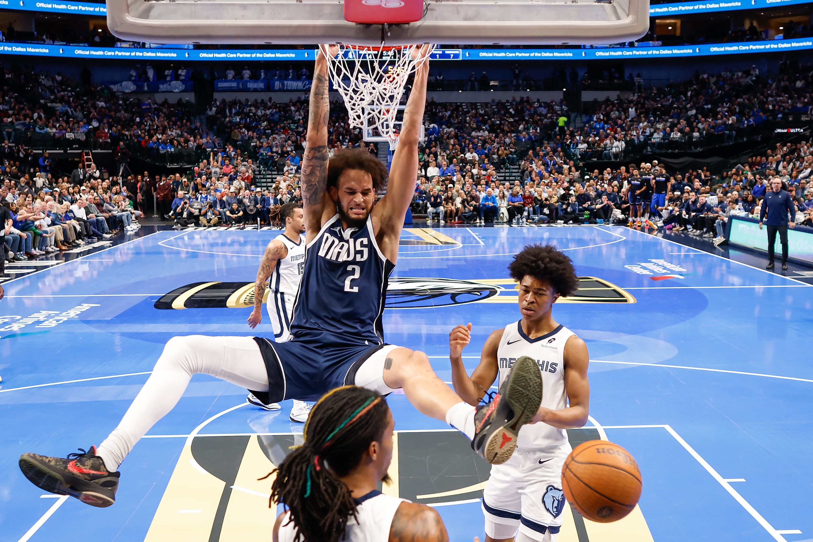 Dallas Mavericks center Dereck Lively II (2) dunks past Memphis Grizzlies guard Ja Morant...