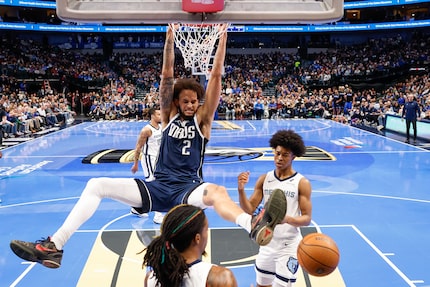 Dallas Mavericks center Dereck Lively II (2) dunks past Memphis Grizzlies guard Ja Morant...