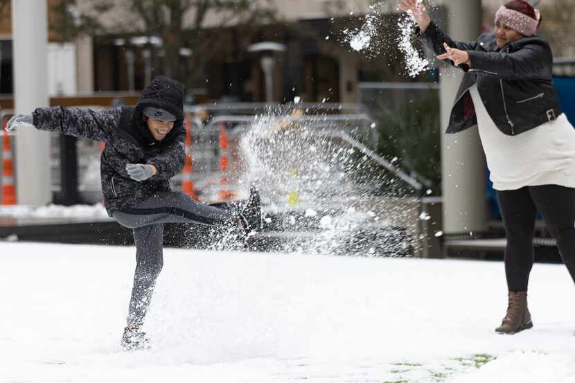 Emerson Mata, de 10 años juega con la nieve junto a su madre Vanessa López en la plaza AT&T...