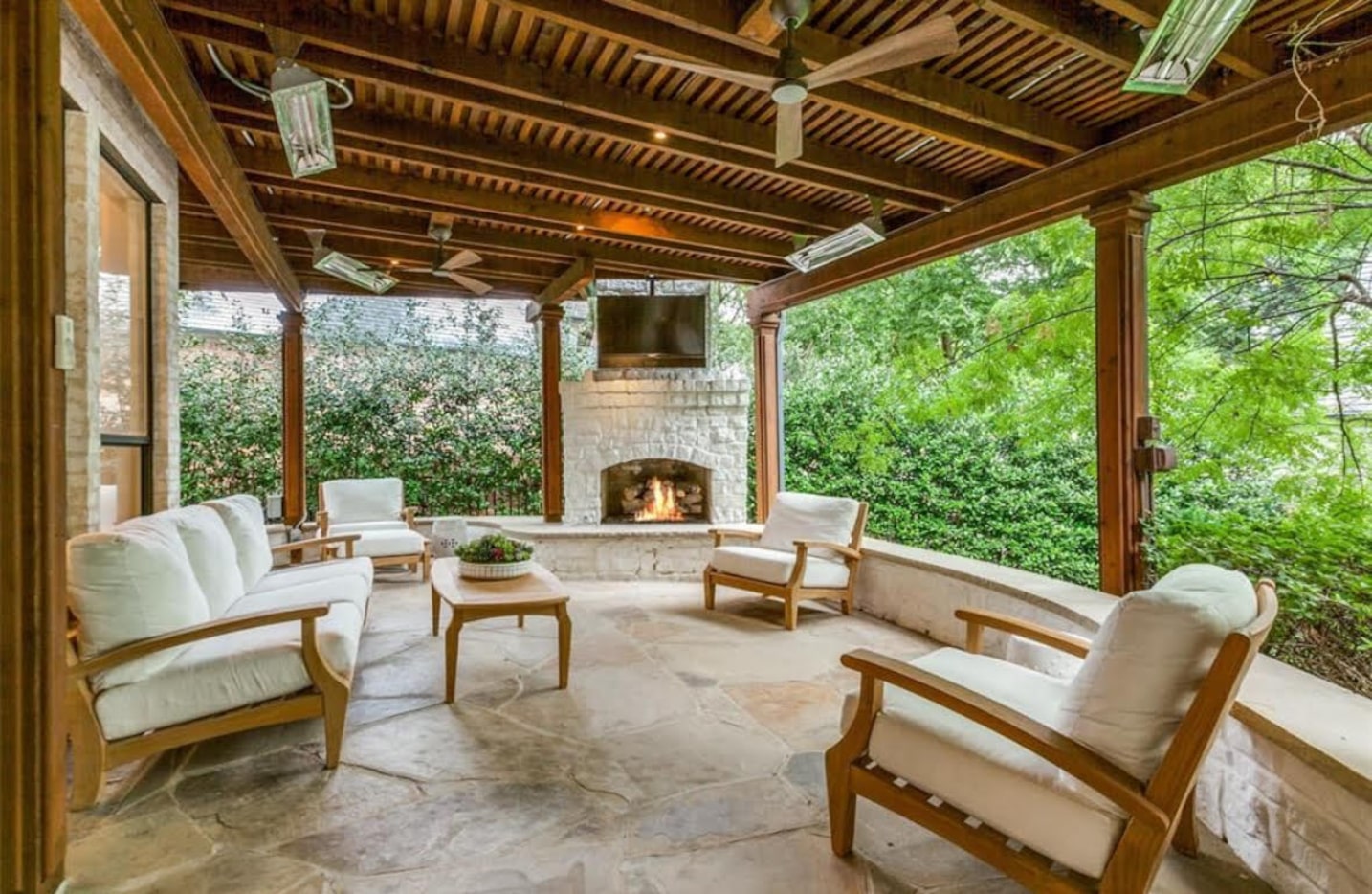 A built-in stone fireplace sets a cozy ambiance on the spacious covered patio.