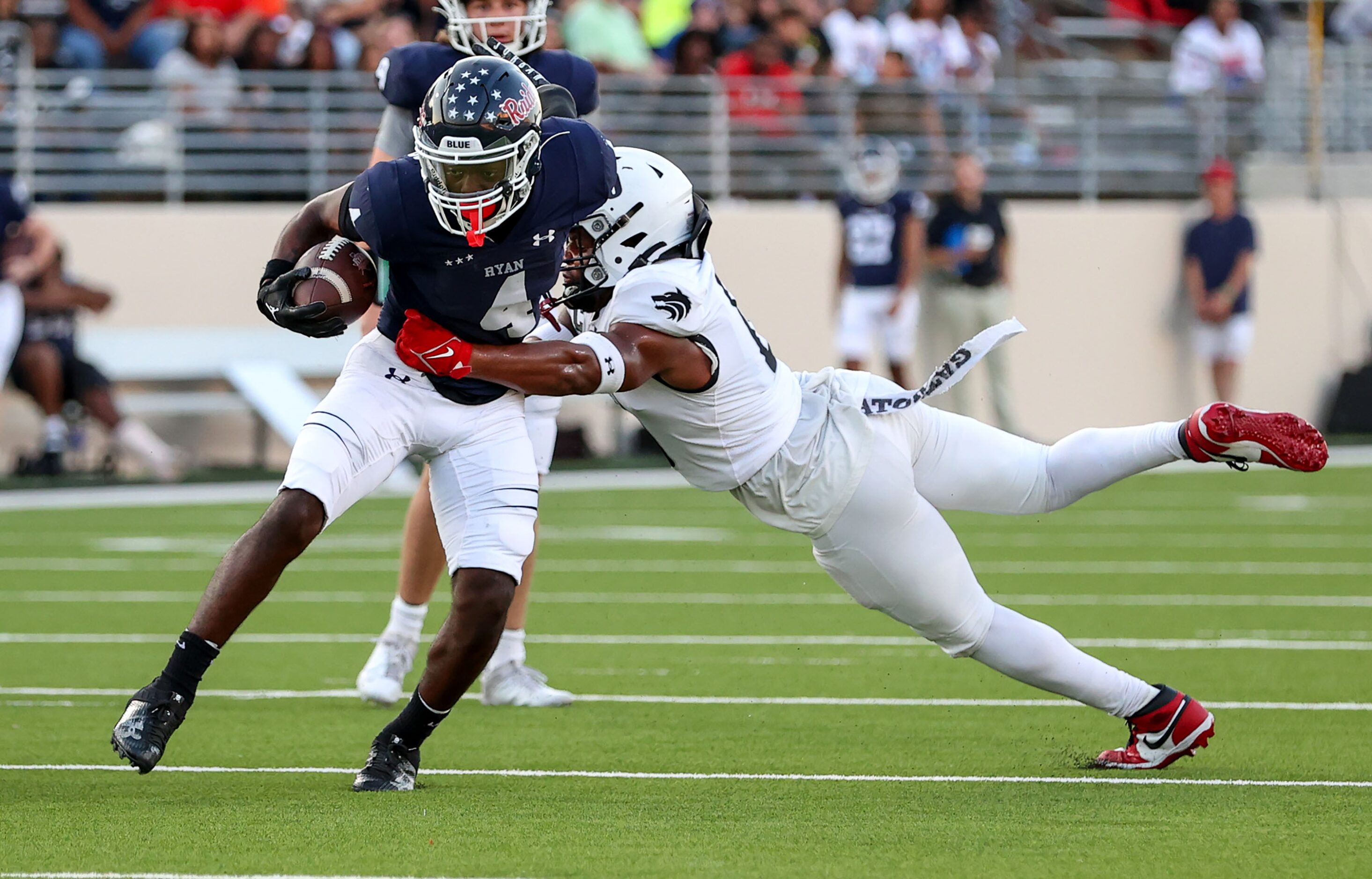 Denton Ryan running back Tre'Vaughn Reynolds (4) breaks a tackle from Mansfield Timberview...