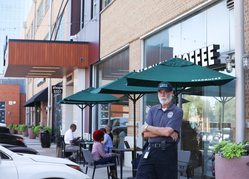 A man working security at Mockingbird Station stands by the shopping mall's Starbucks store...