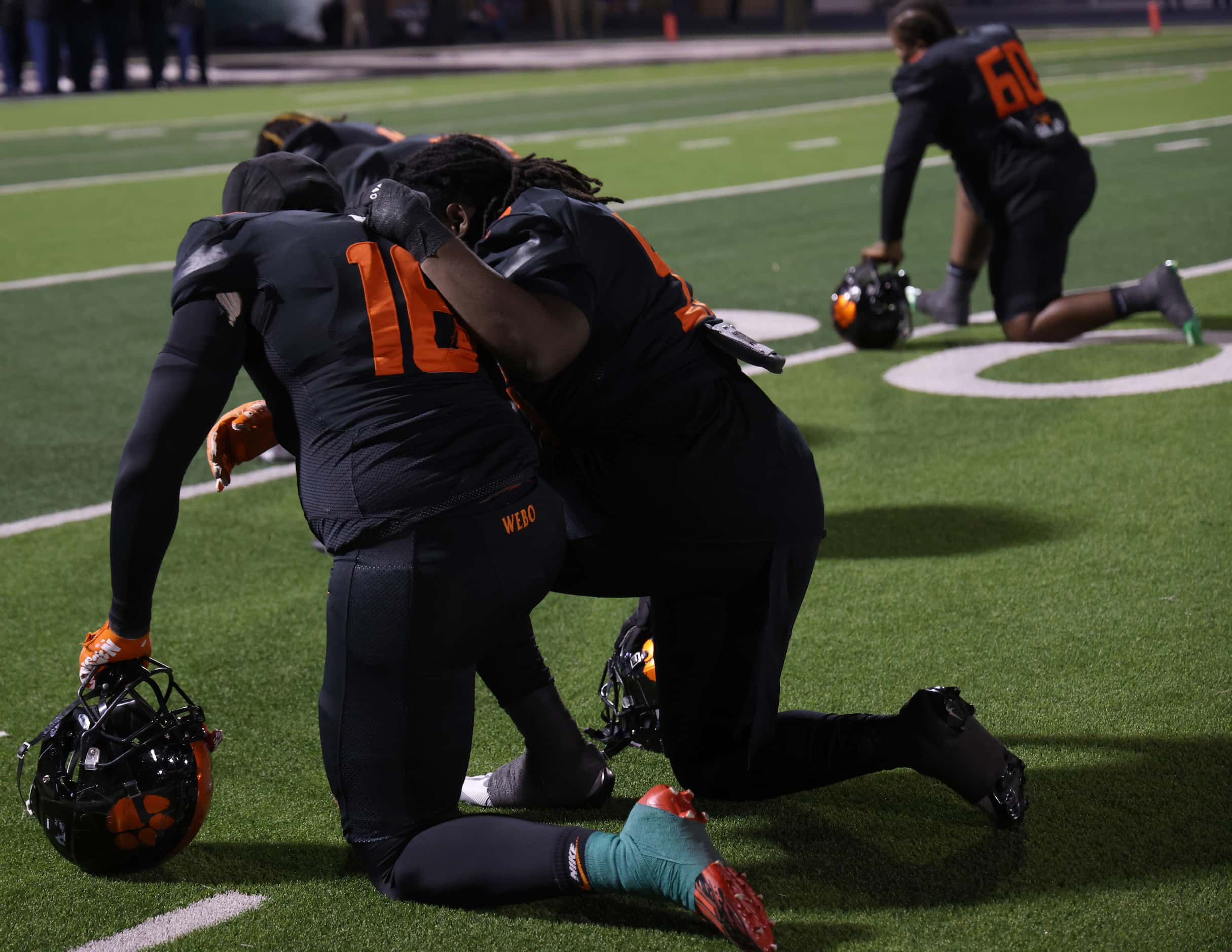 Lancaster players pause to pray after taking the field before the opening kickoff against...