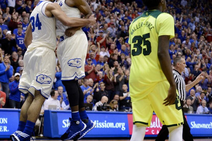 After breaking away for a dunk, Kansas Jayhawks' Perry Ellis, left, gets a celebratory chest...
