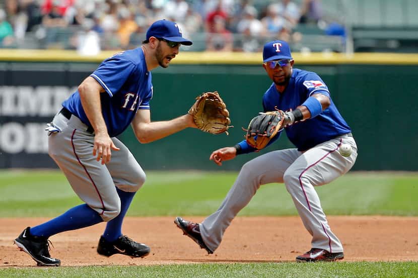 CHICAGO, IL - JUNE 20: Adam Rosales #9 of the Texas Rangers (L) fields the ball next to...