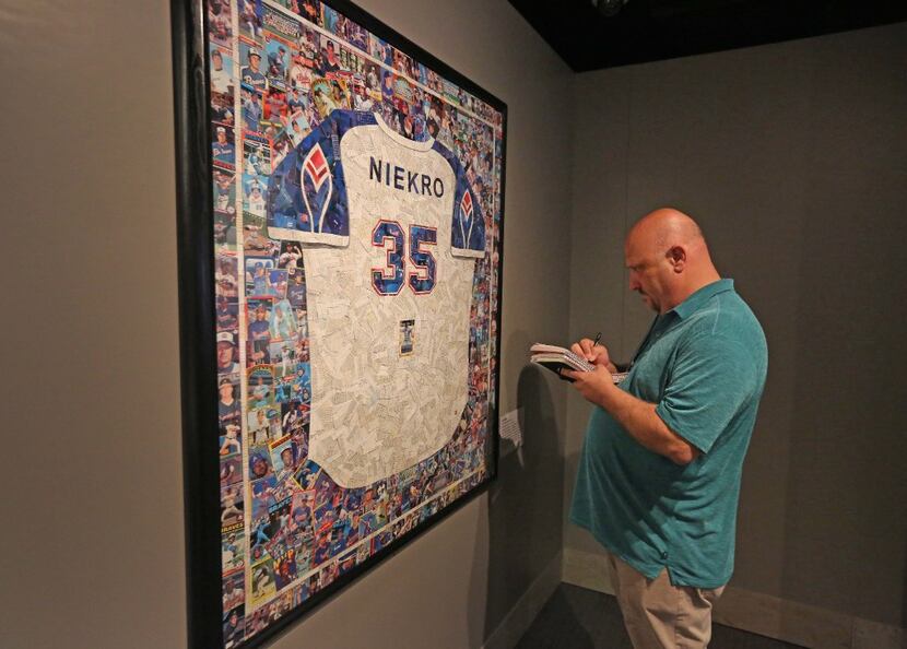The Dallas  Morning News baseball writer Evan Grant examines a mosaic of baseball cards in...