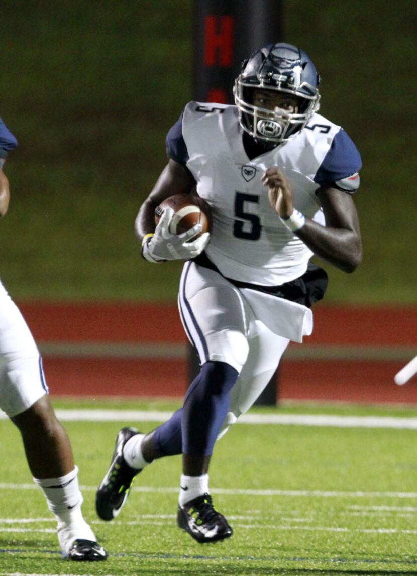 Wylie East QB Eno Benjamin (5) looks for an opening during the first half of a high school...