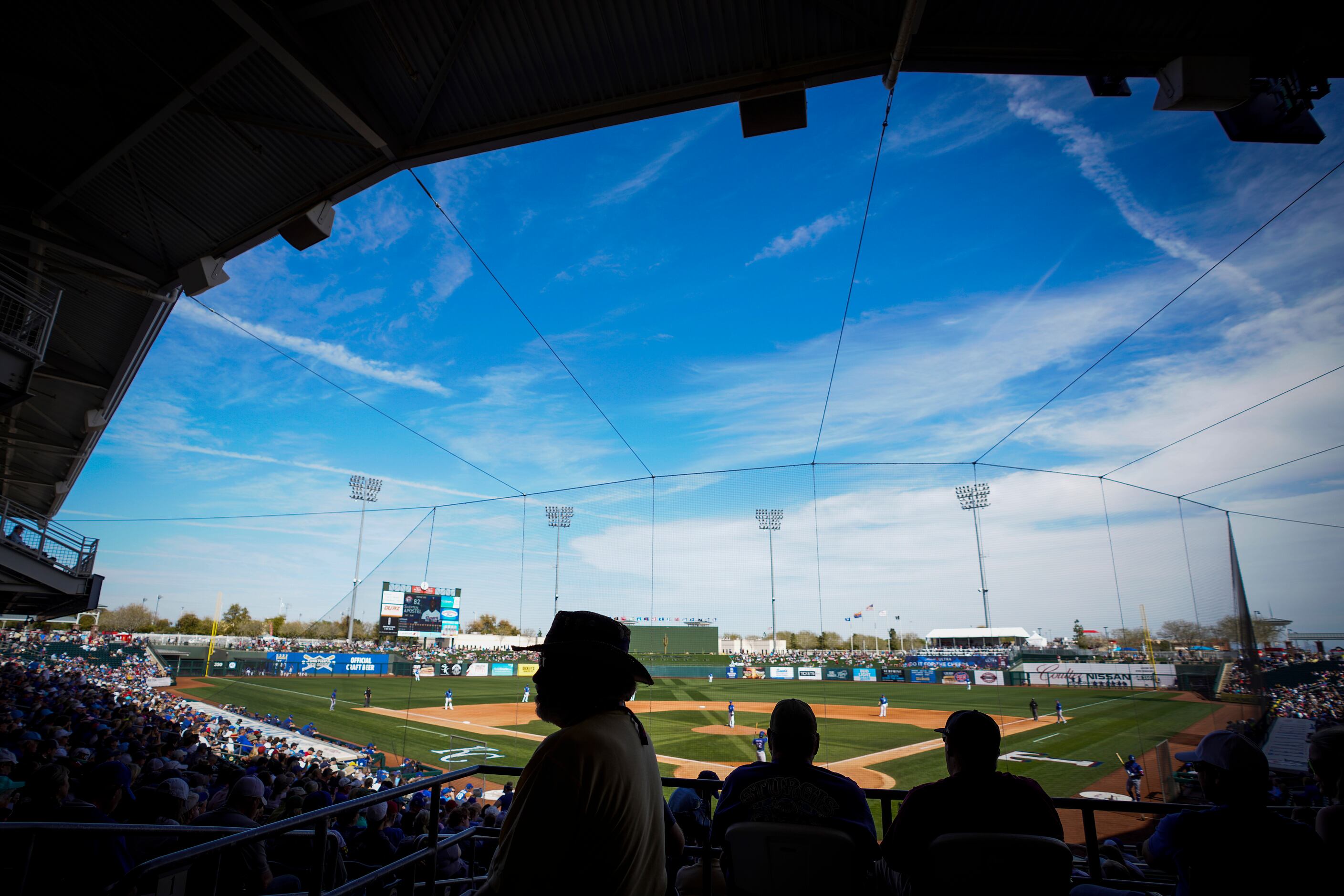 Fans watch the Texas Rangers face the Kansas City Royals in a spring training game at...