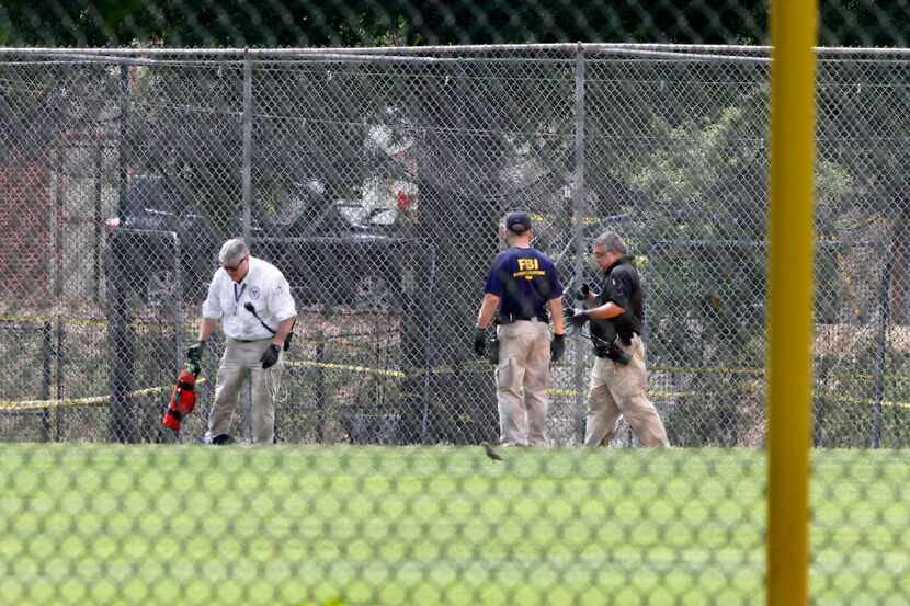 FBI agents continue to search for evidence on the baseball field in Alexandria, Va.,...