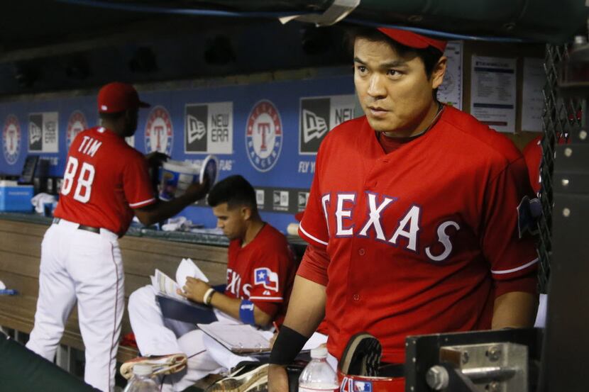 Texas outfielder Shin-Soo Choo watches from the dugout as he gathers his gear as the Blue...