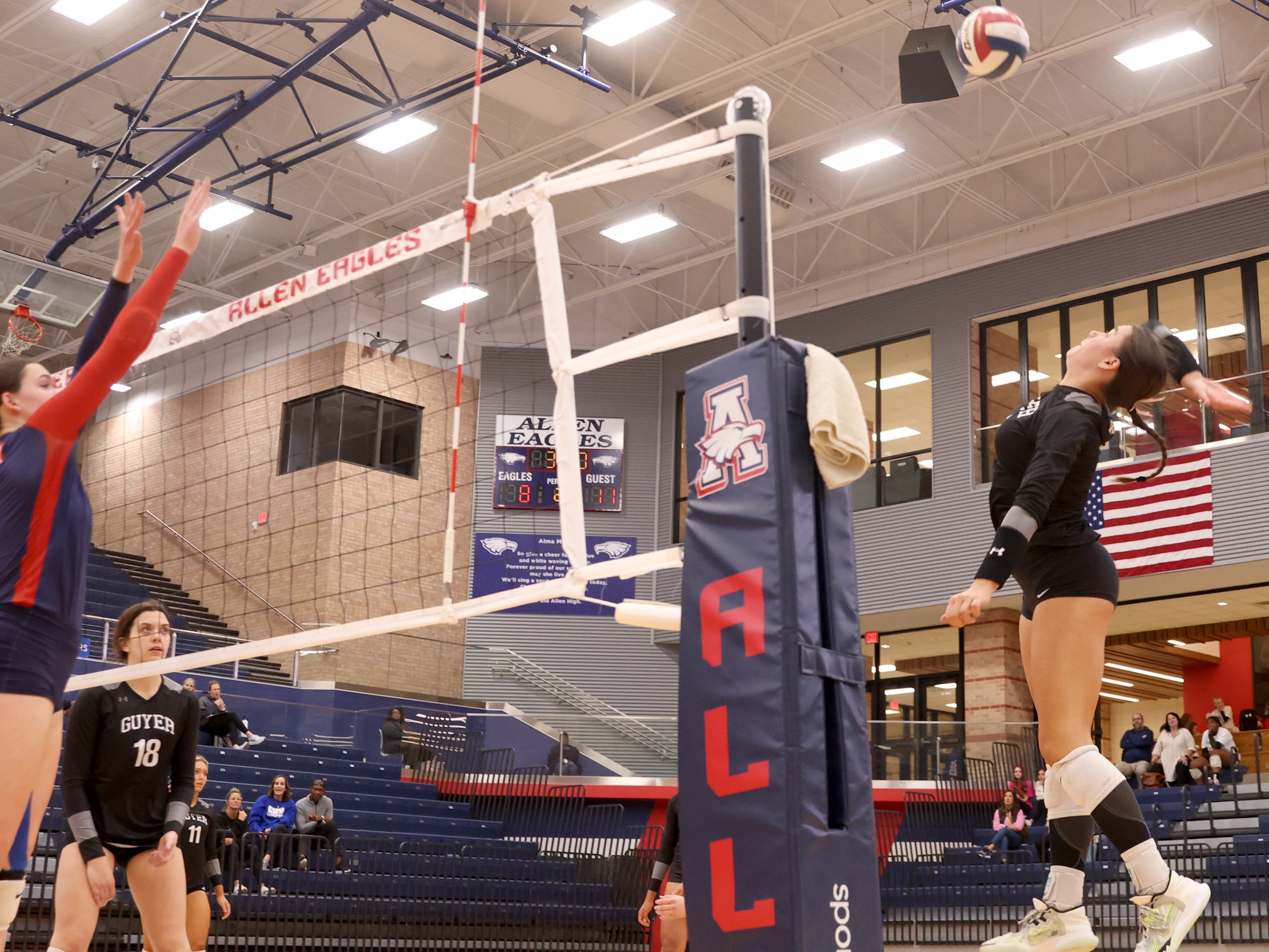 Denton Guyer senior Lauren Schneider (9) prepares to spike the ball over the net toward...