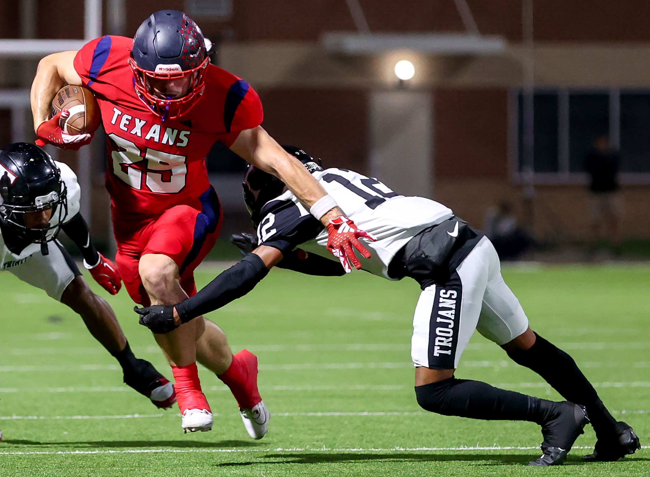 Justin Northwest wide receiver Mason Fritz (25) breaks a tackle from Trinity defensive back...