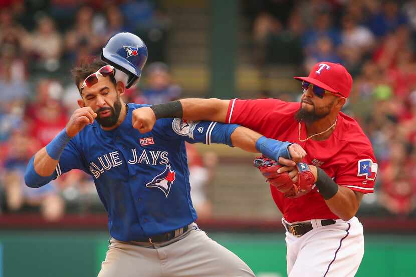 FILE - In this May 15, 2016, file photo, Toronto Blue Jays' Jose Bautista, left, is hit by...