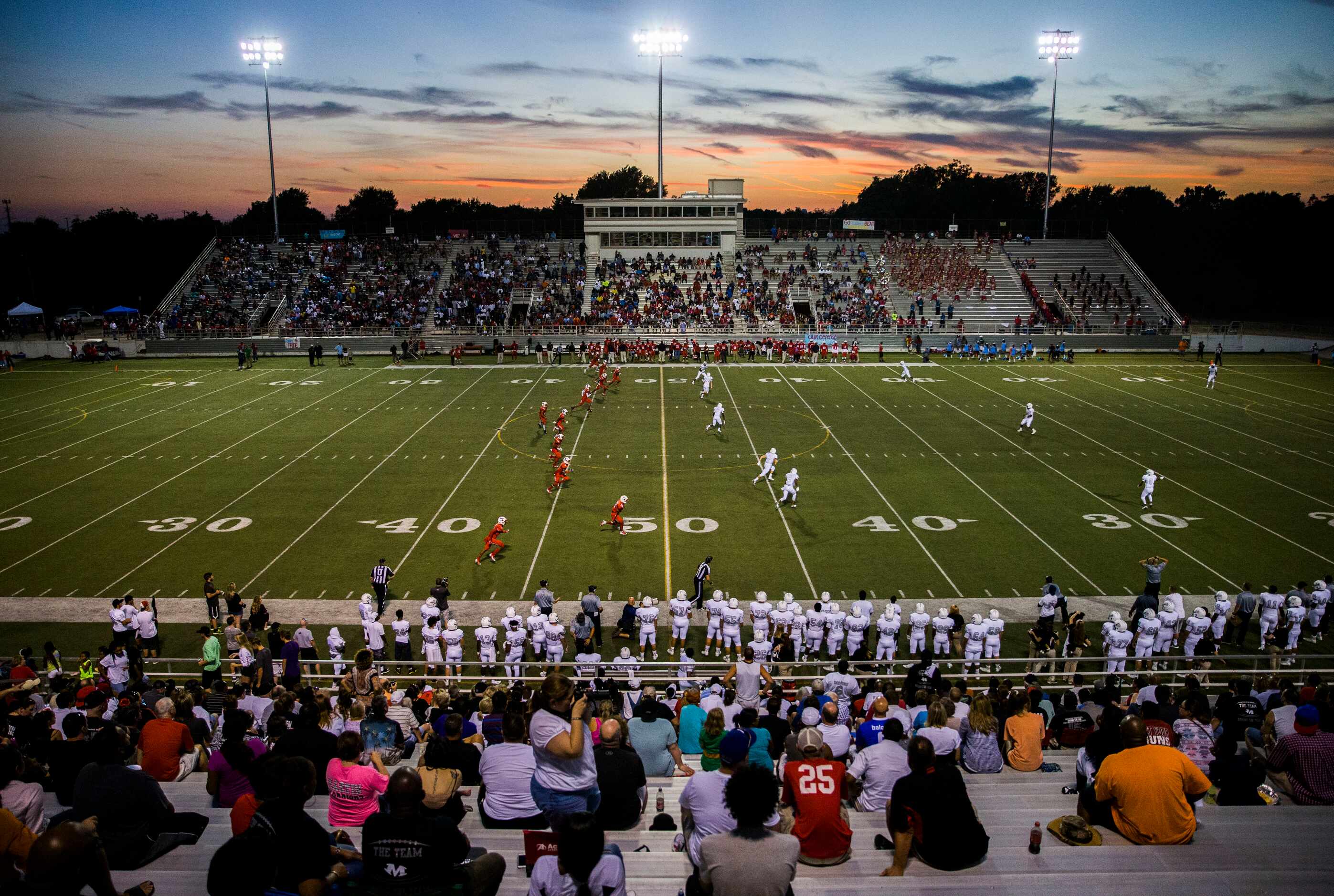 The sun sets over Forester Field during the first quarter of a high school football game...