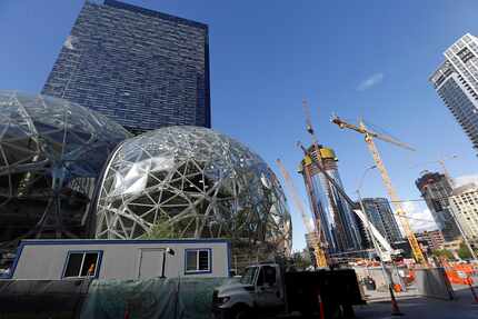 Large spheres take shape in front of an existing Amazon building (back) as new construction...