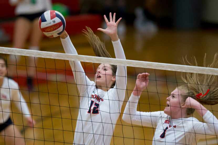 McKinney Boyd's Paige Anderson (12) blocks the ball during avarsity volleyball match against...