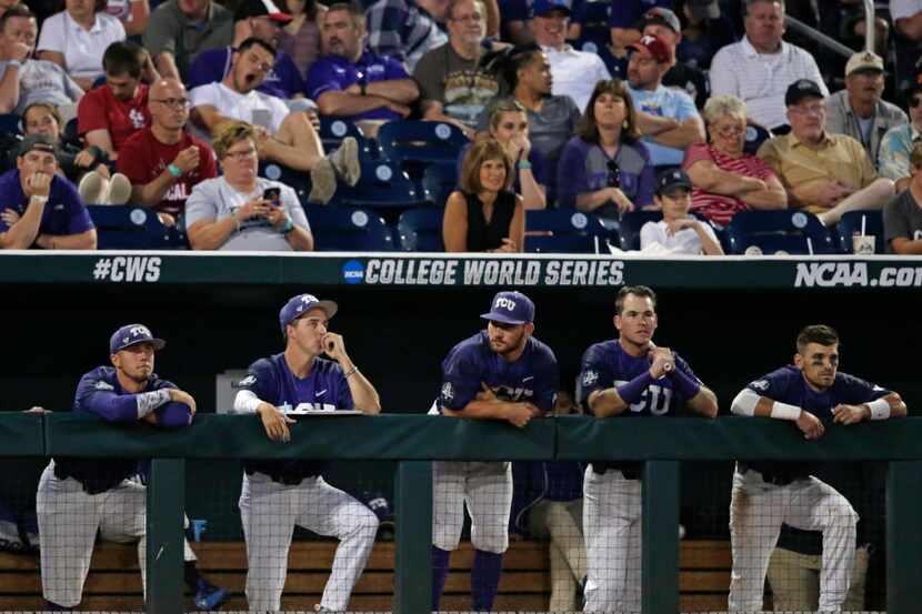 The TCU dugout watches as they trail in the seventh inning of an NCAA College World Series...