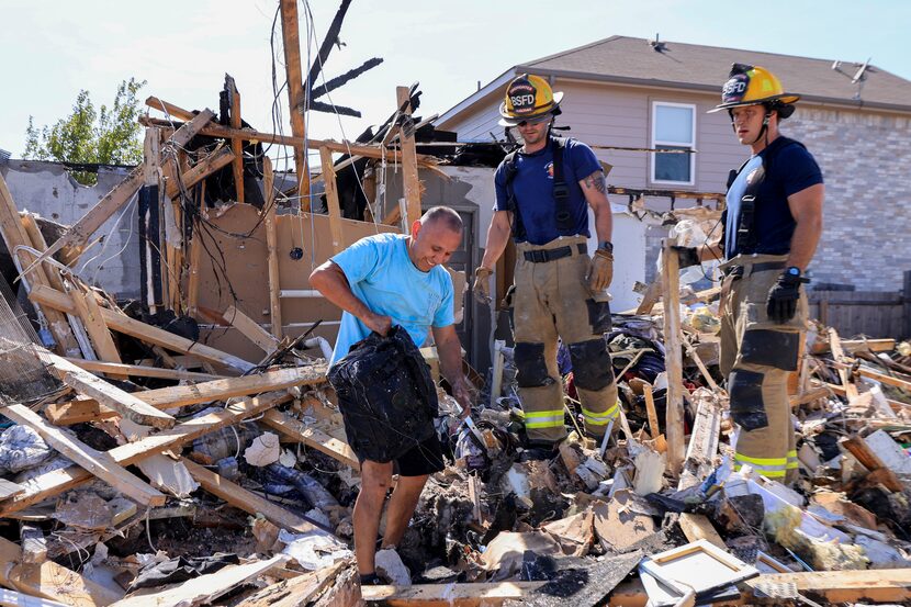 Miguel Quinonez (left) smiled after finding a bag Tuesday that contained his and his wife’s...