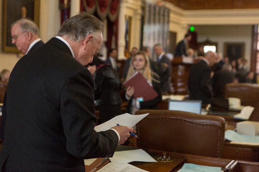 Rep. Dan Flynn works at his desk on the House floor before presenting House Bill 3158, which...