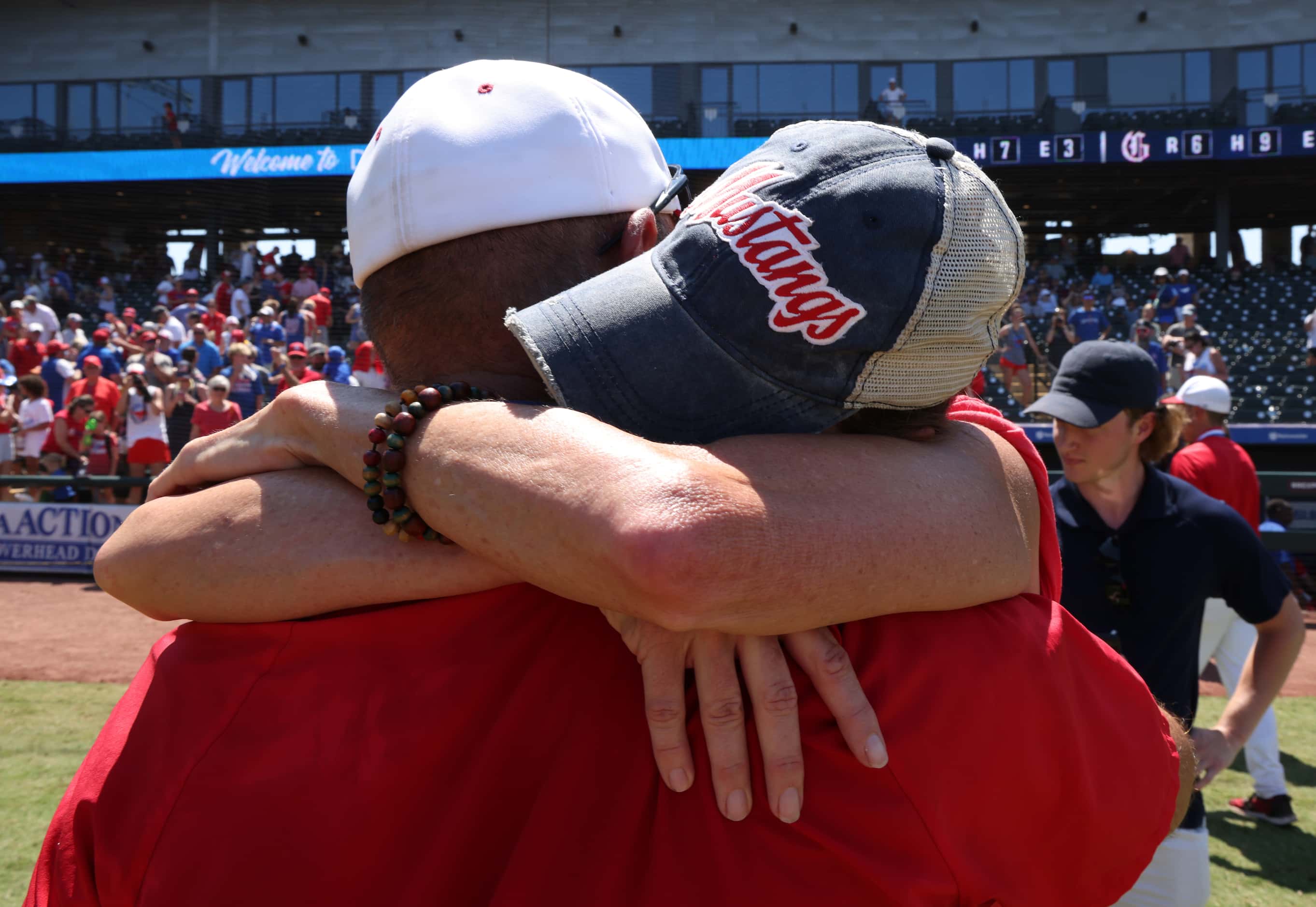 Grapevine head coach Jimmy Webster receives a hug from his wife following the Mustangs' 6-5...