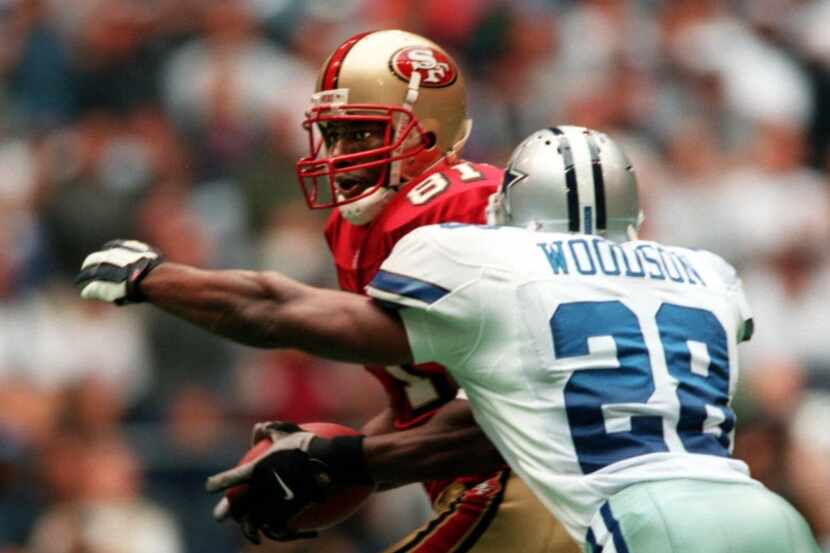 Cowboys safety Darren Woodson, 28, lunges to tackle 49er receiver Terrell Owens, 81, during...
