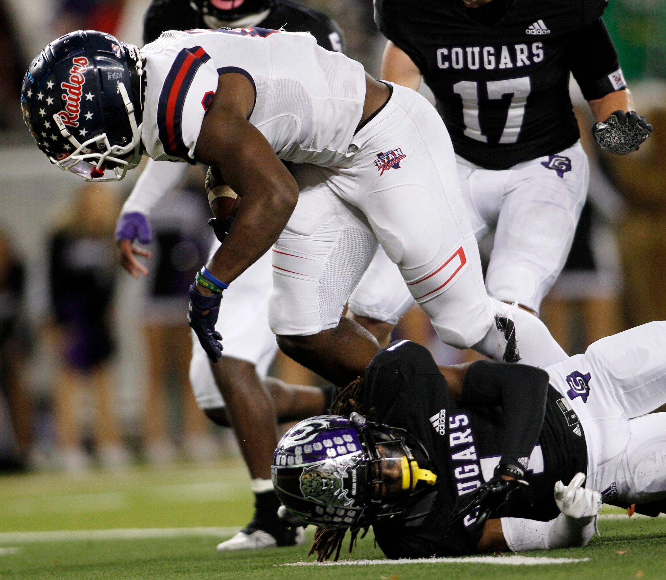 Denton Ryan running back Kalib Hicks (2) pulls from the grasp of College Station defensive...