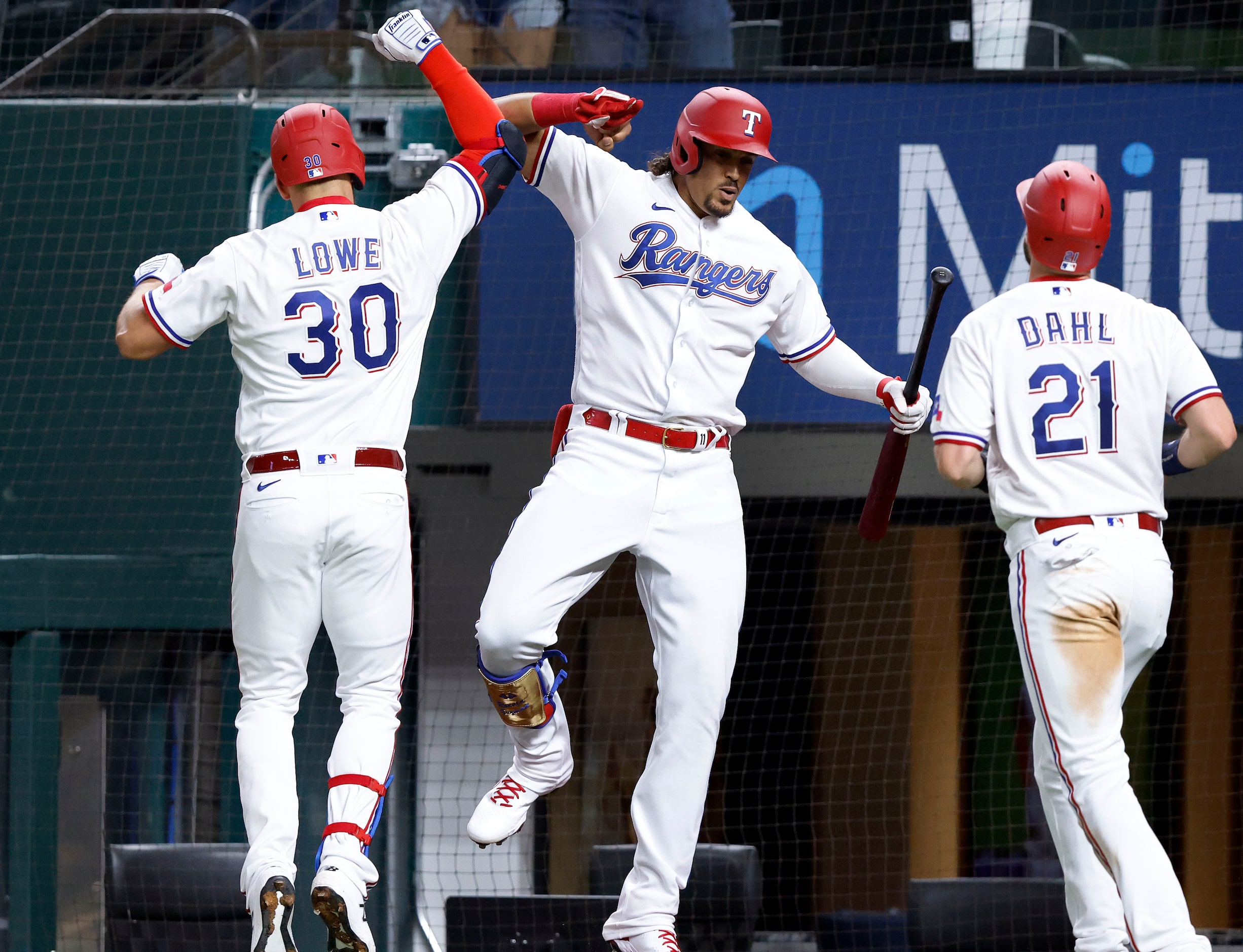 Texas Rangers batter Nate Lowe is congratulated by teammate Ronald Guzman after connecting...