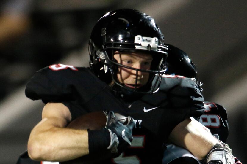 Euless Trinity running back Toby Harrah (5) feels the squeeze of a kickoff runback that come...